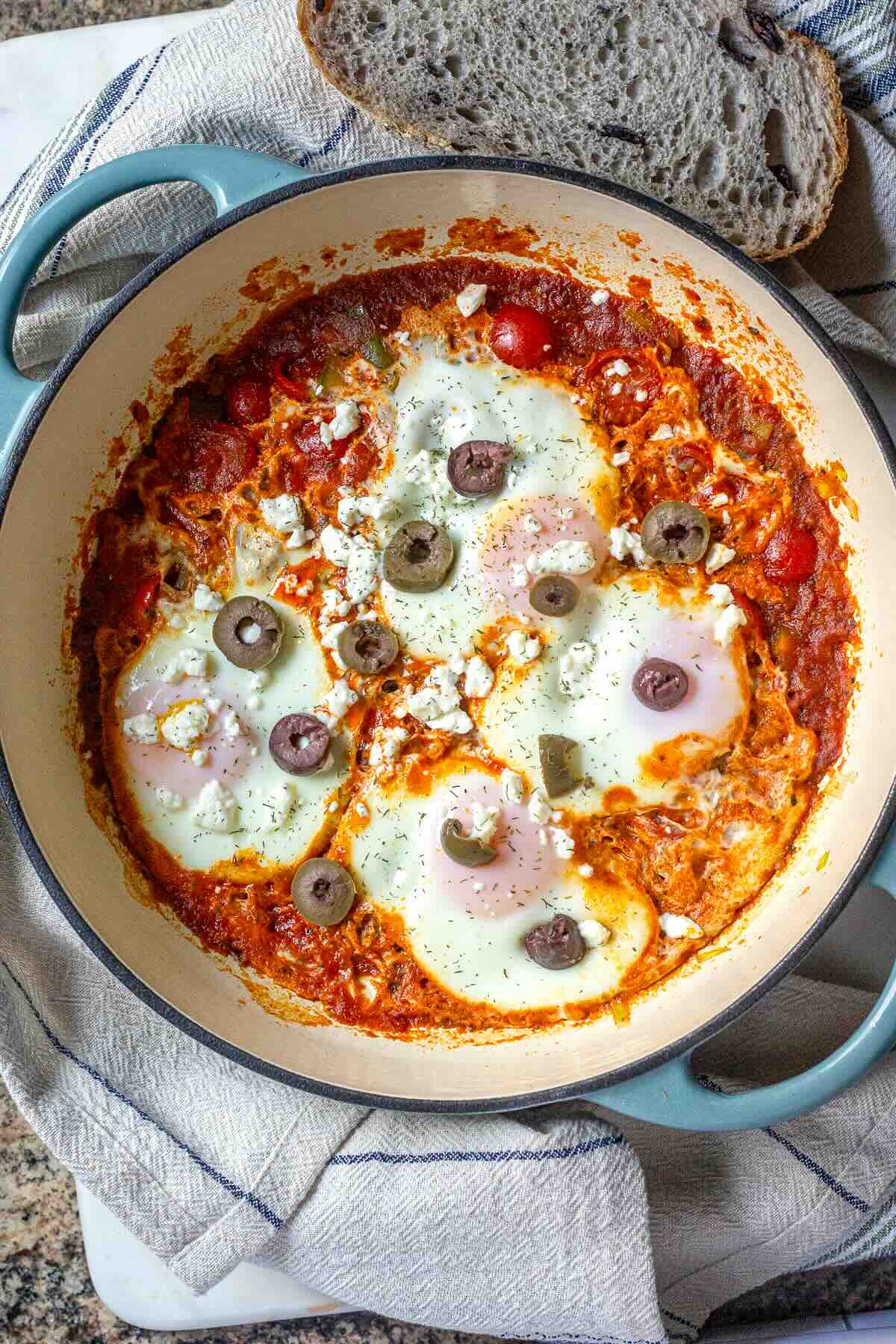 Healthy shakshuka breakfast with leeks, eggs, and rich tomato sauce in a cast-iron pan.