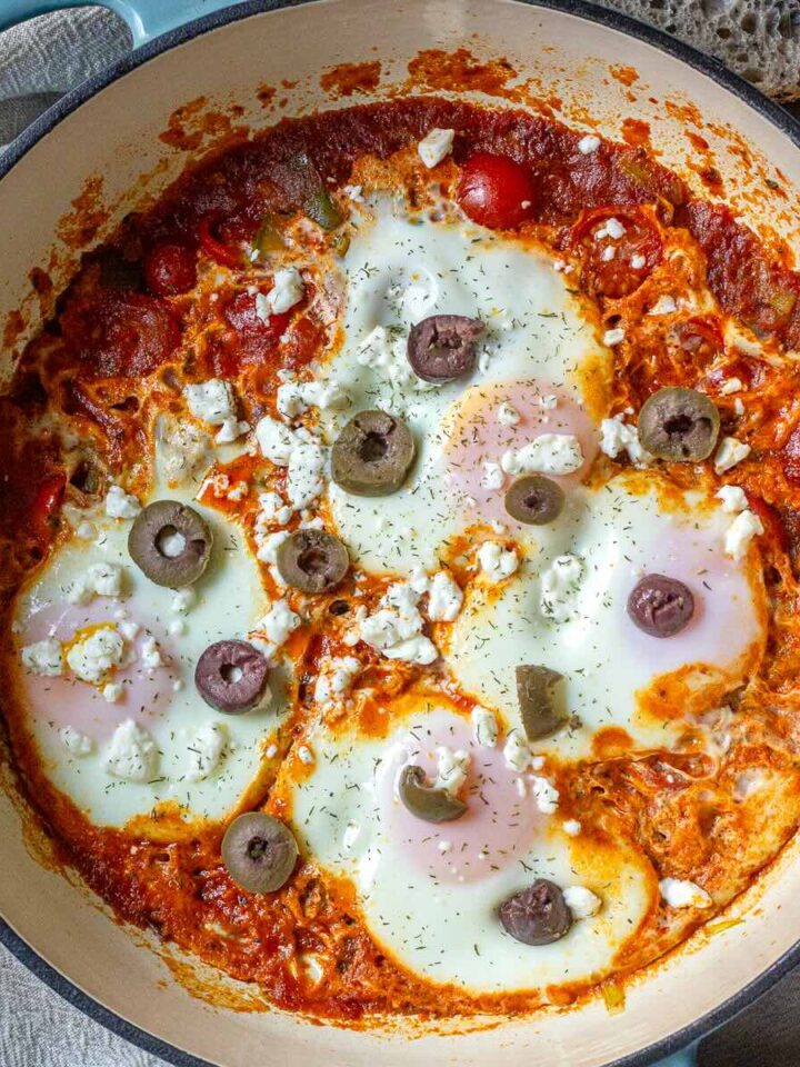 Easy Shakshuka with leeks served in a pan with olives on top.