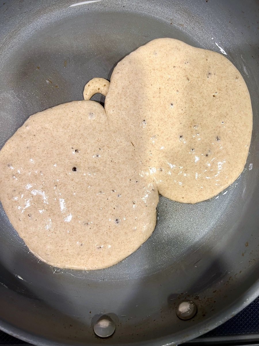 Fluffy whole wheat pancakes with kefir in a pan.