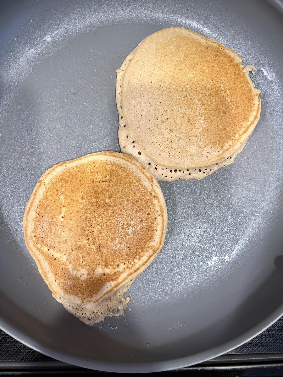 Fluffy whole wheat pancakes with kefir in a pan.