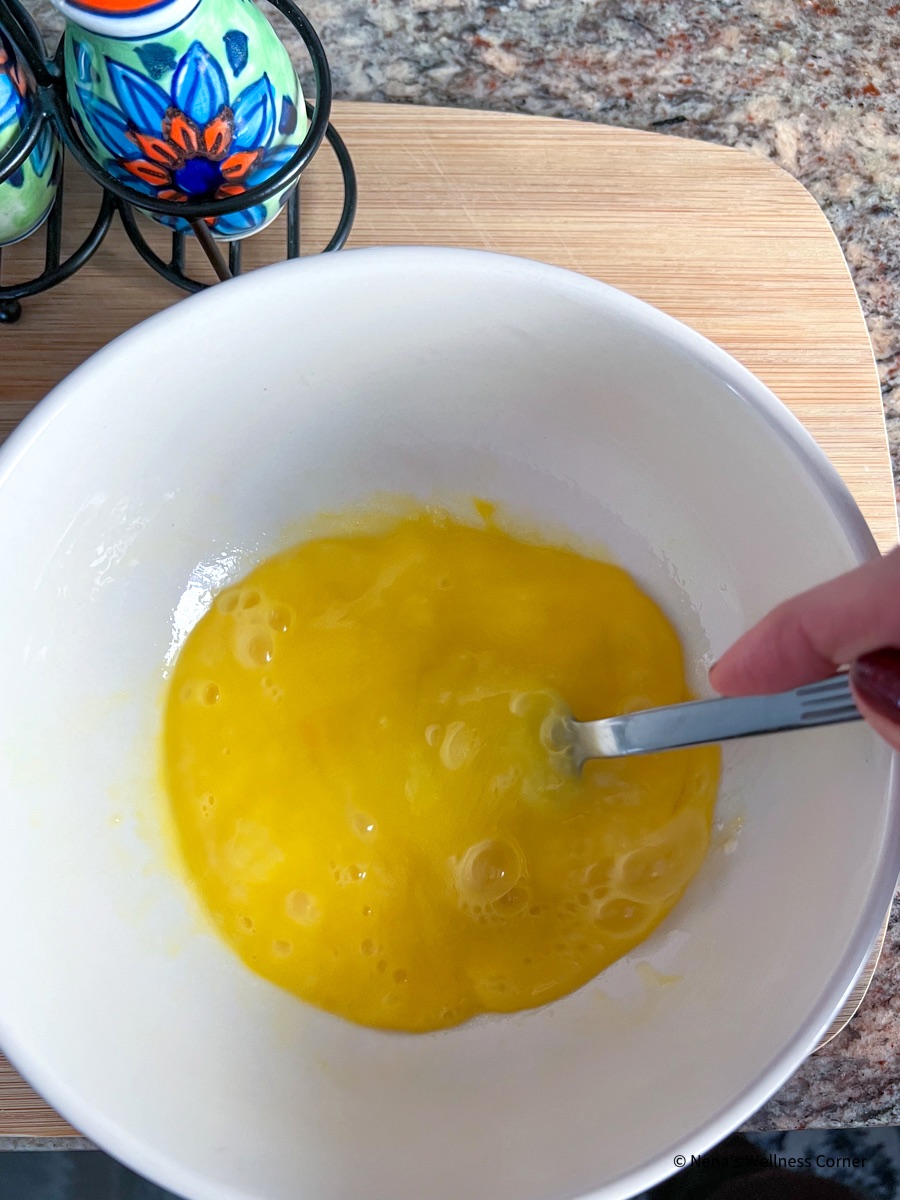 Cheesy Scrambled Eggs, whisk the eggs with water.