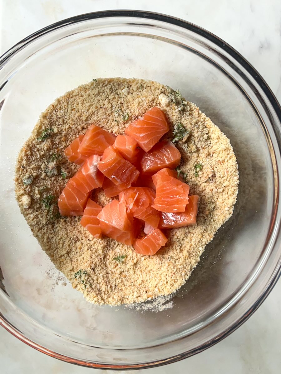 Air Fryer Salmon Bites with Garlic, add salmon bites to spices mix.
