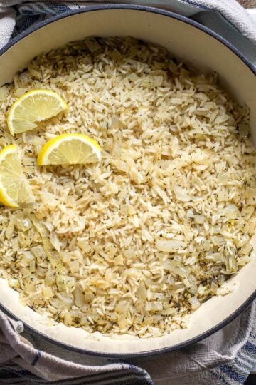 Mediterranean rice shown in a Dutch oven skillet and decorated with lemon