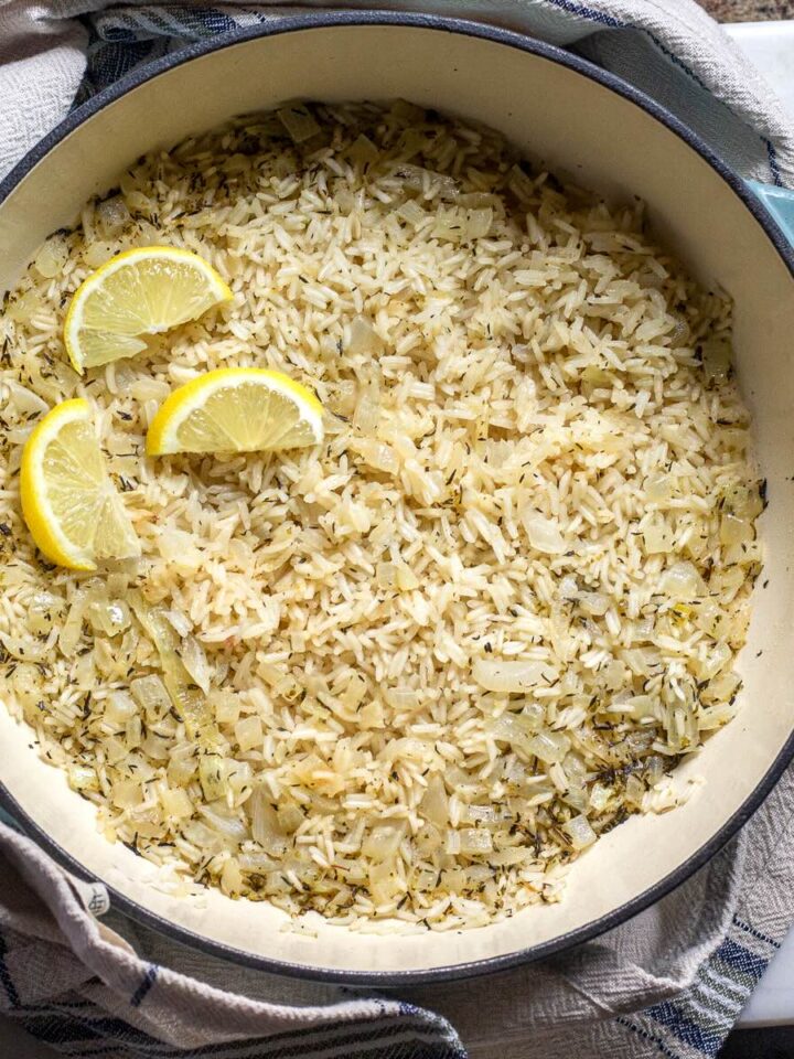 Mediterranean rice shown in a Dutch oven skillet and decorated with lemon