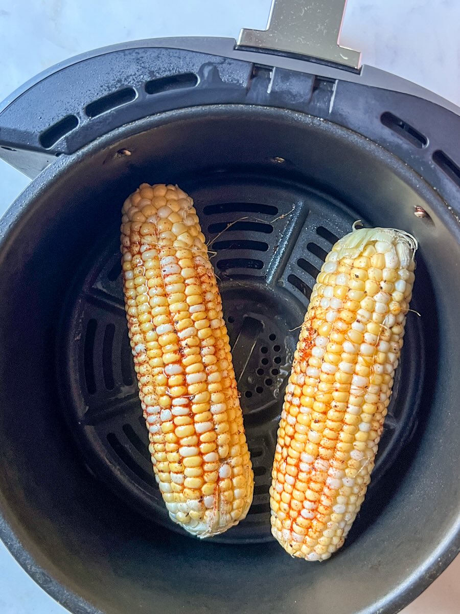 Ninja air fryer corn on the cob, place corn into the air fryer.