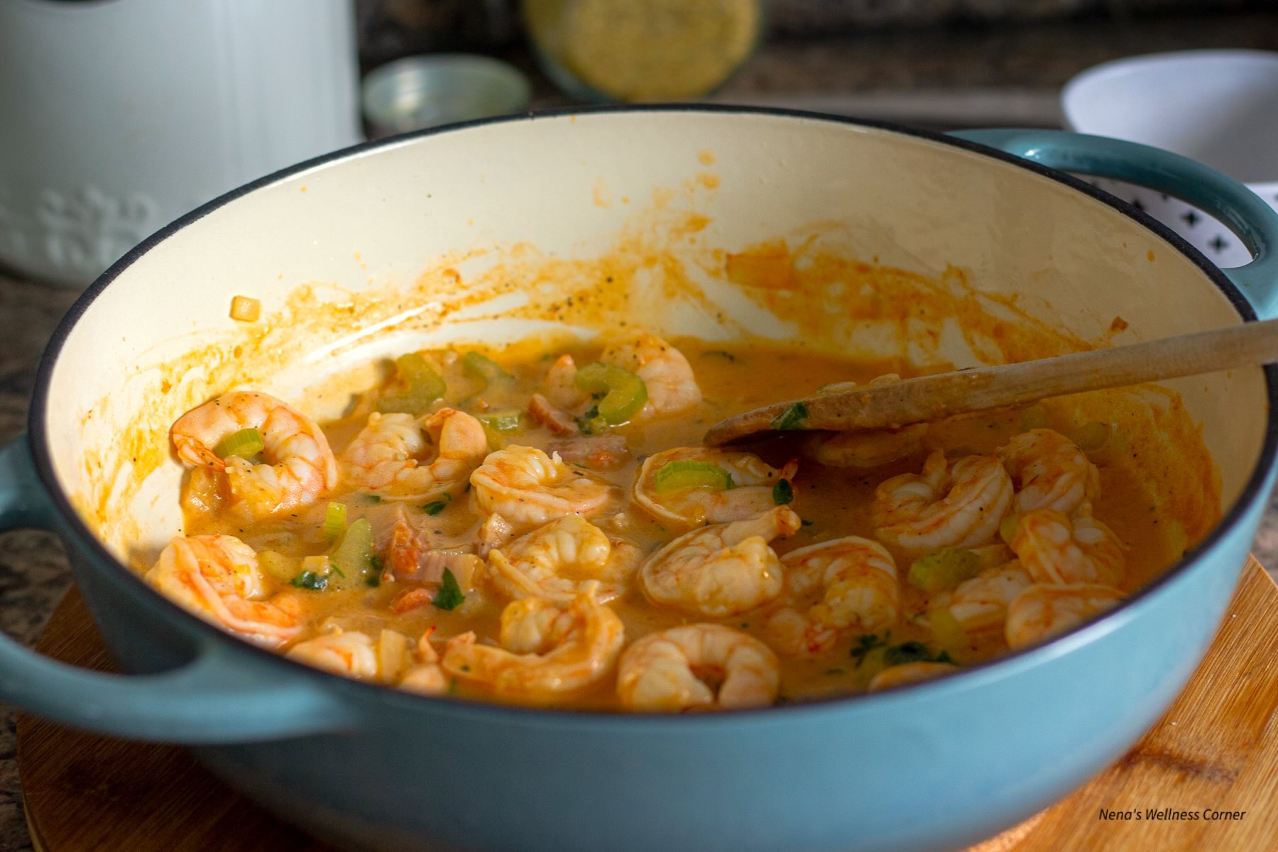 Cooked shrimp in a tomato and white wine sauce shown in a large skillet 