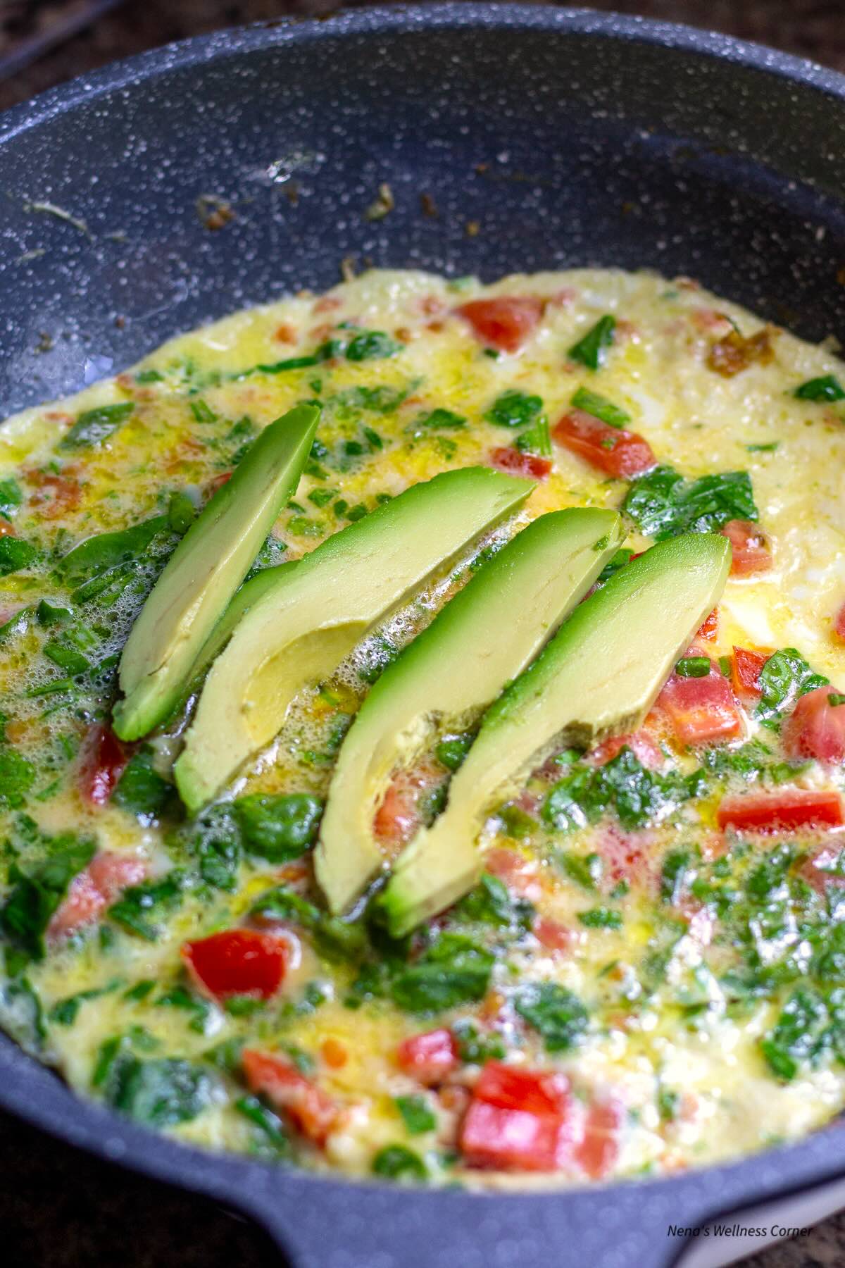 Avocado omelette with spinach and tomato before folding