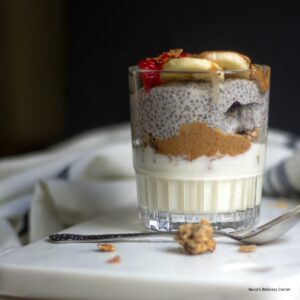 Chia yogurt parfait served in a glass with granola, fruit and almond butter