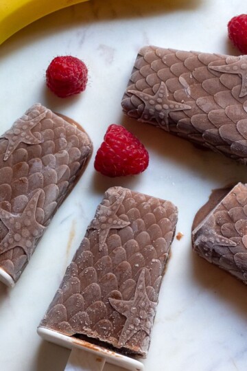 Chocolate and banana popsicles with raspberries
