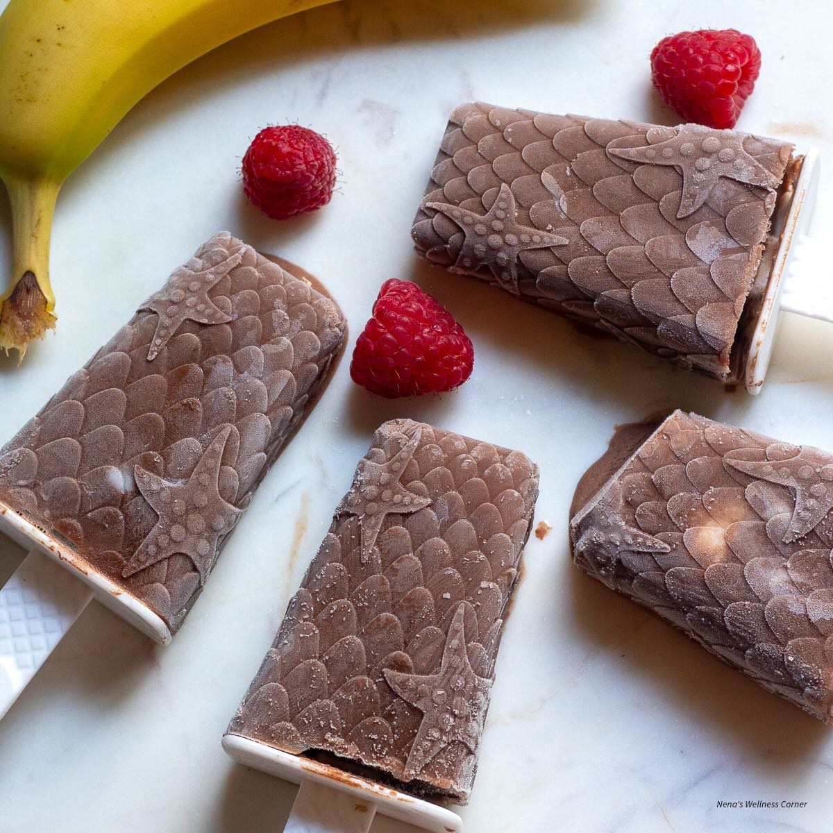 Chocolate and banana popsicles with raspberries