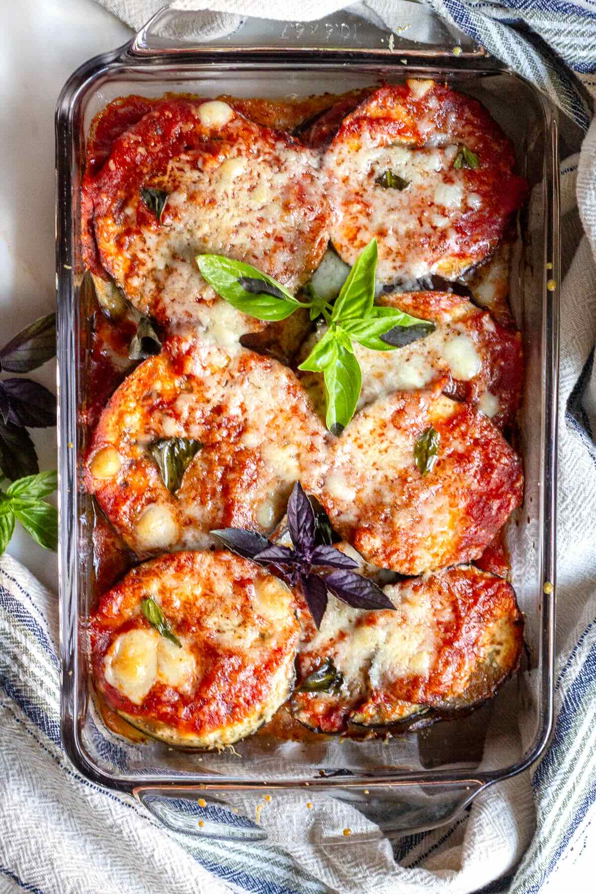 Melted cheesy eggplant casserole with tomato sauce and fresh basil.