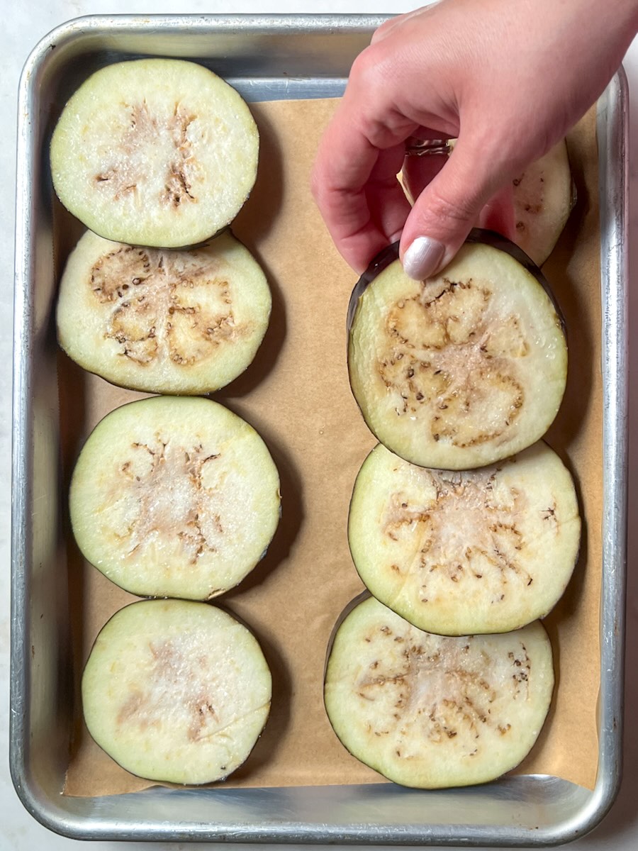 Baked cheesy eggplant, arrange eggplant slices on the parchment paper and bake.