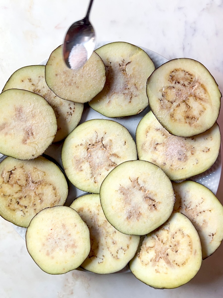 Baked cheesy eggplant, sprinkle eggplant with salt.