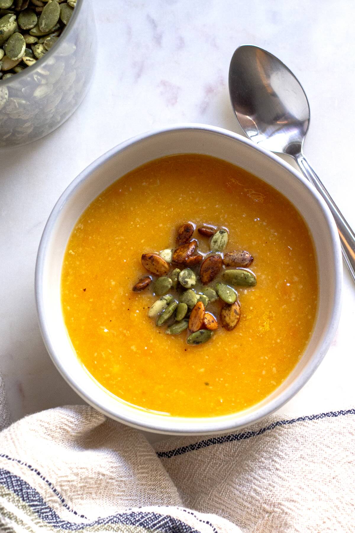 Sweet Potato and Zucchini and Garlic Soup Served in a Bowl with Pumpkin Seeds.