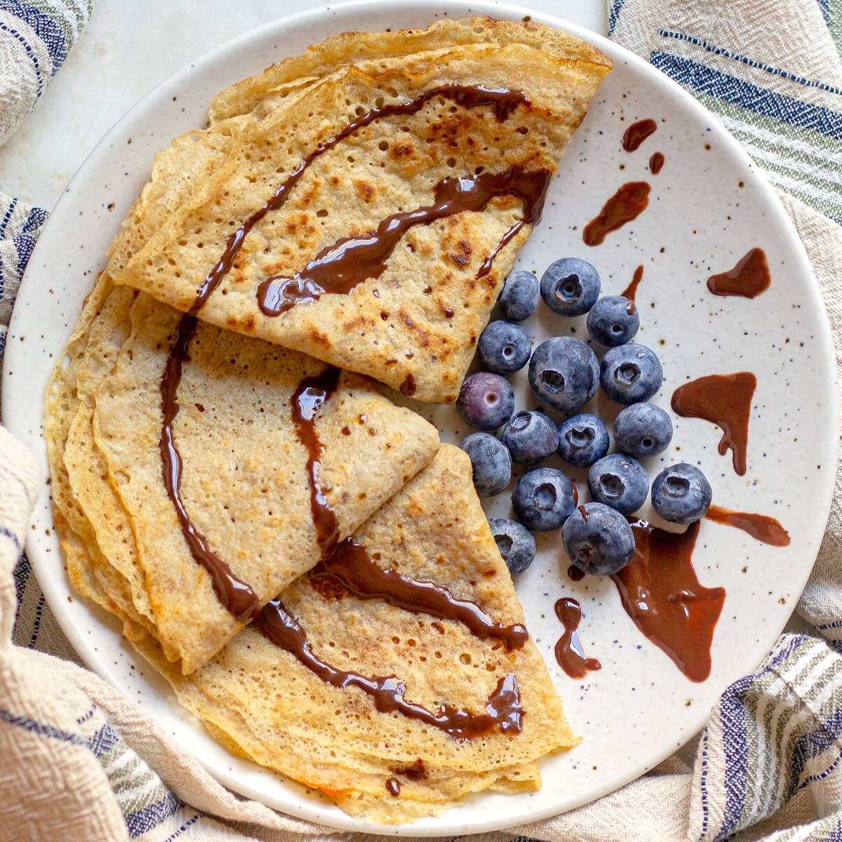 Whole-wheat crepes served on a plate with blueberries