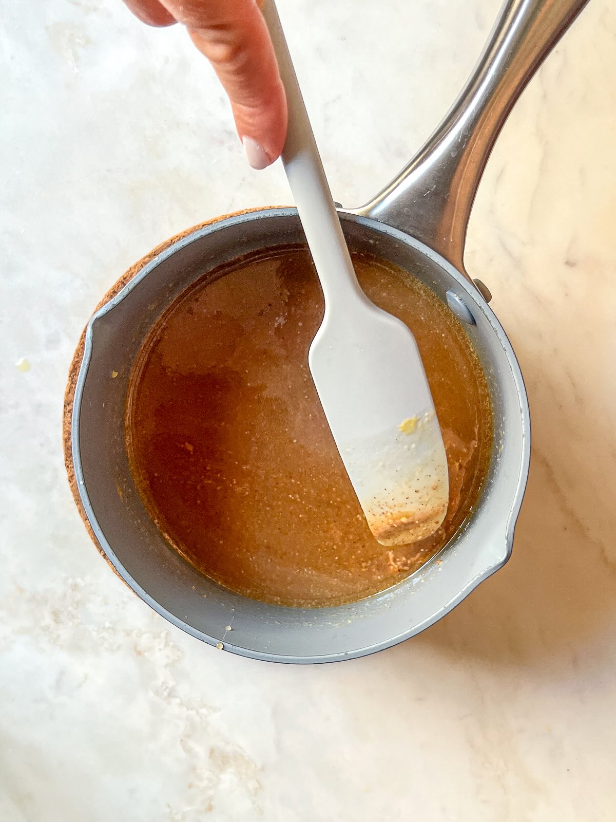 Wet ingredients for homemade granola bars without peanut butter, including almond butter, melted coconut oil, maple syrup, and orange juice, ready to be mixed with dry ingredients.