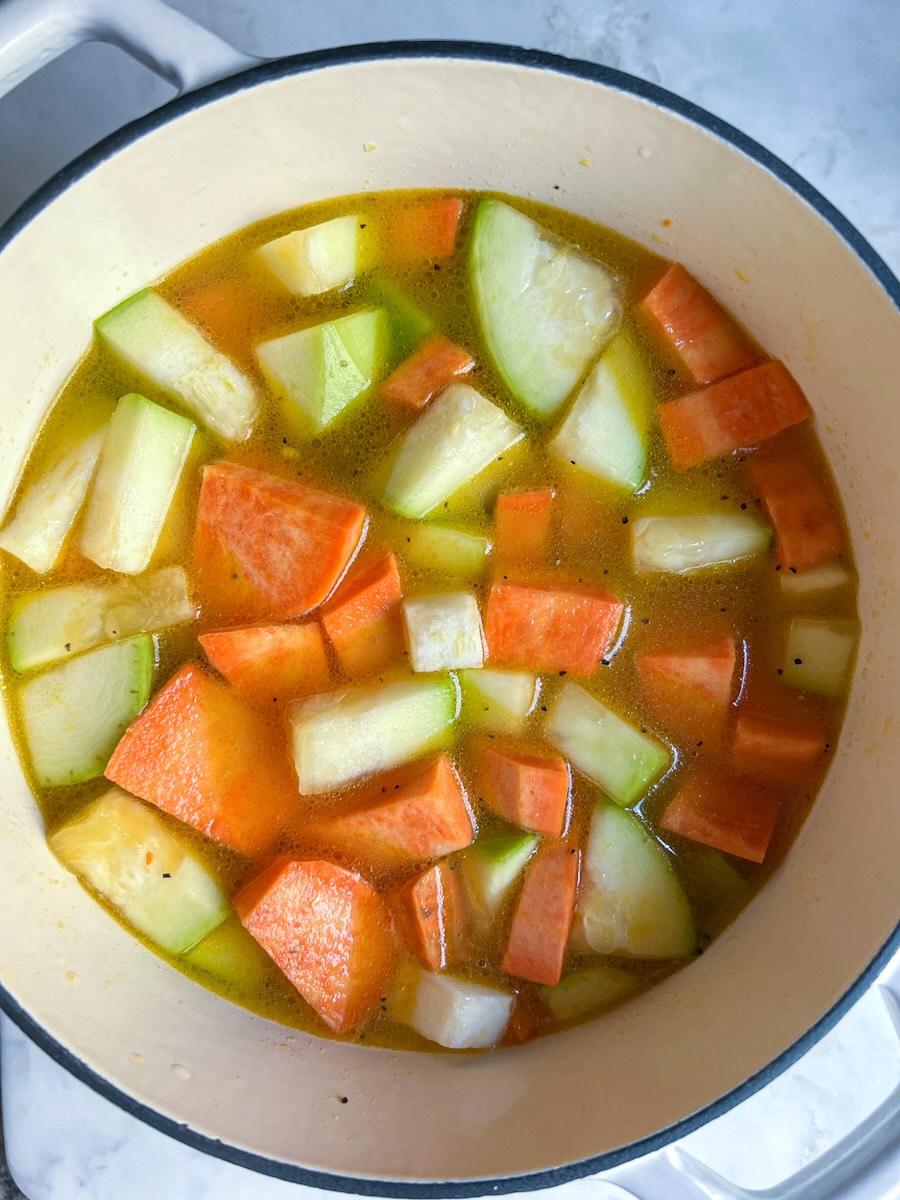 Sweet potato soup with zucchini and garlic, adding water.