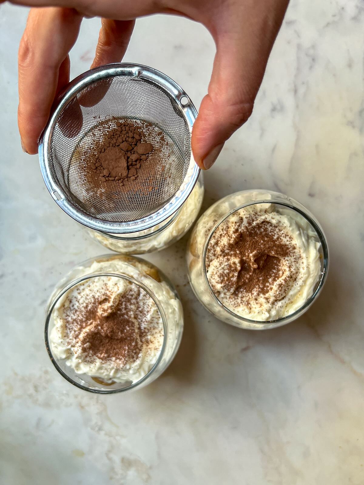 Tiramisu cups without mascarpone, dusting the top with unsweetened cocoa powder. 