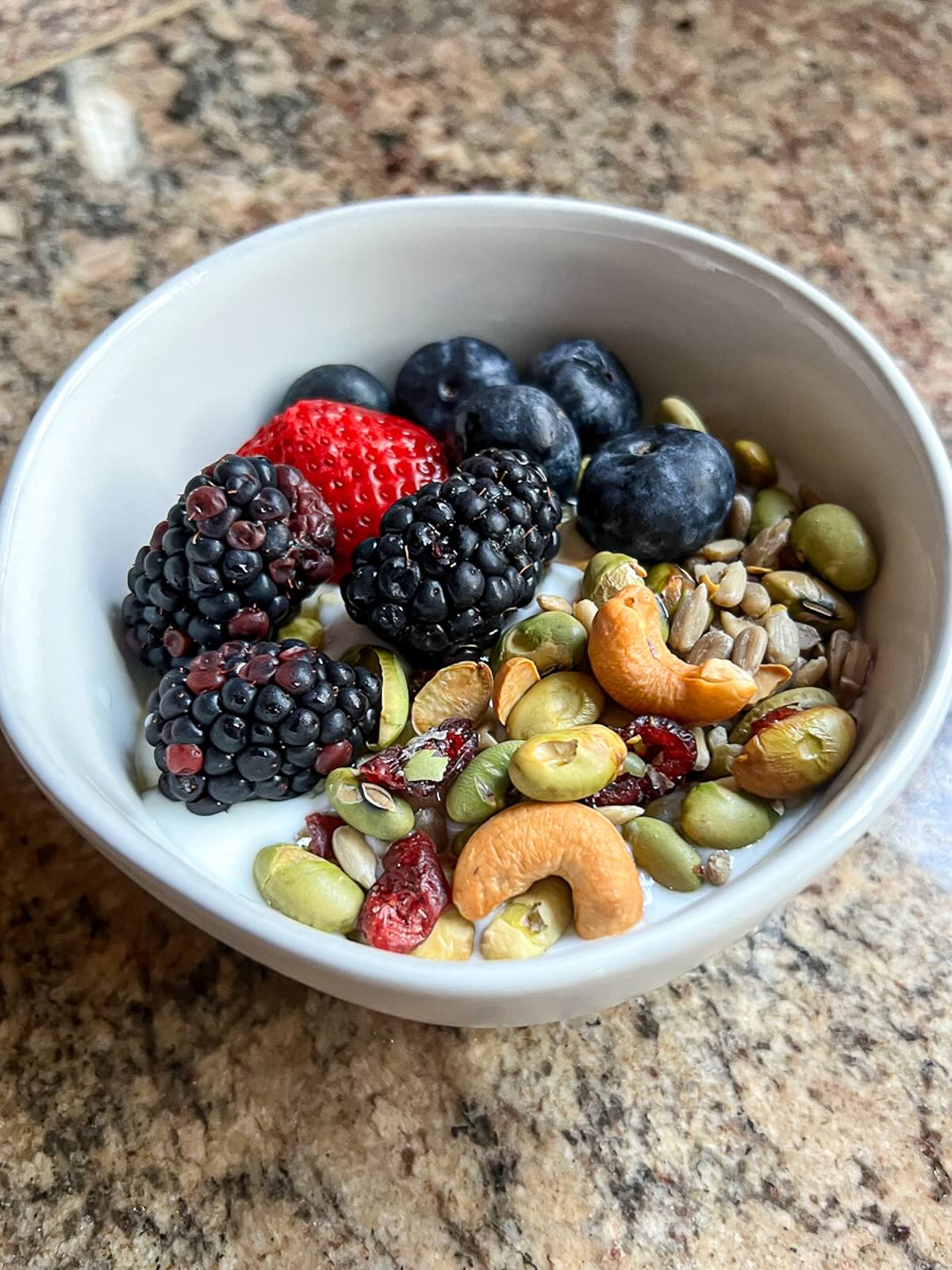 Greek Yogurt Parfait in a bowl with fresh fruits and nuts. 