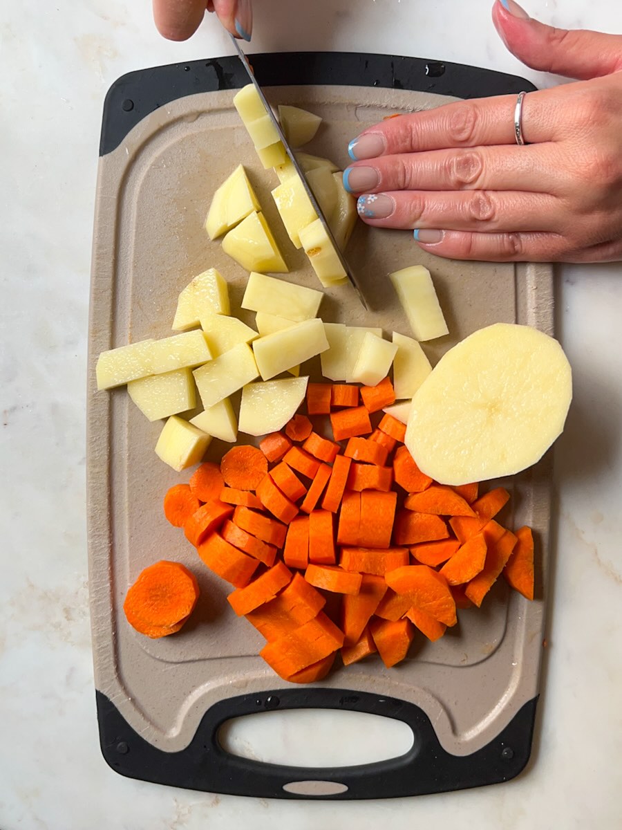 Oven roasted potatoes and carrots with onion and zucchini, cut potatoes and carrots.