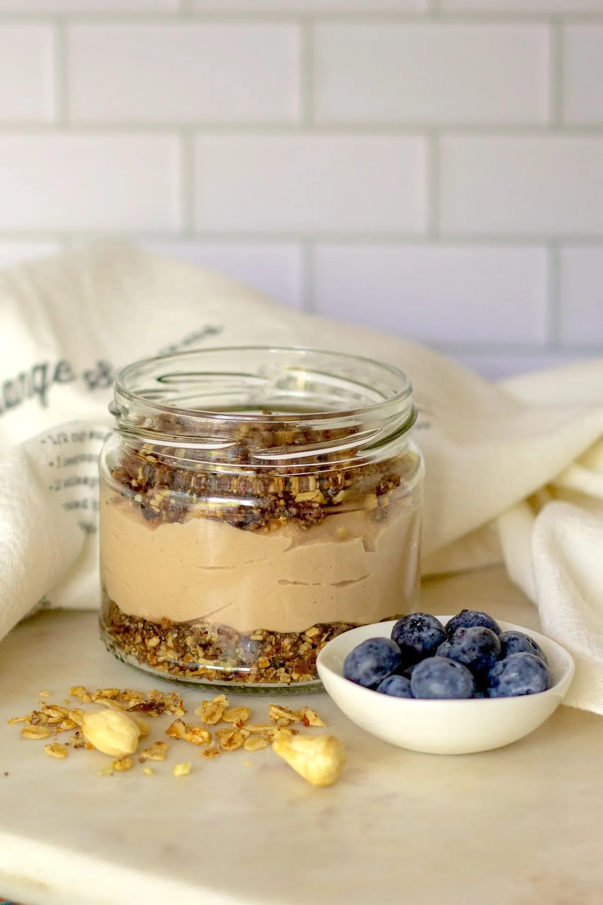 Vegan cheesecake in a jar with date-granola crumb crust and cashew filling